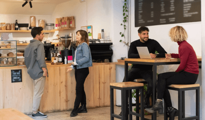People sitting at a coffee shop table discussing personal growth