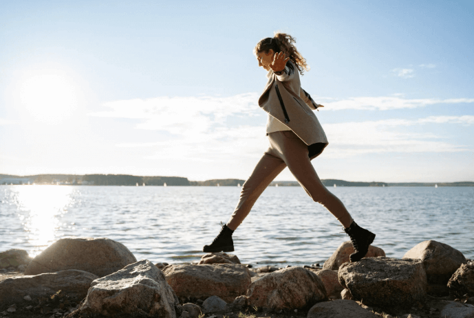 Woman walking on rocks by the water representing ESFP personal growth