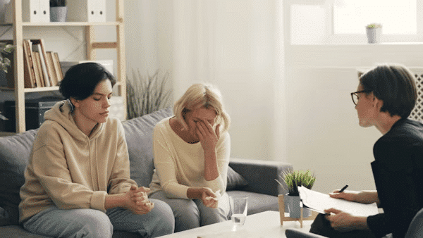 Three women on a couch discussing common reasons for counselling
