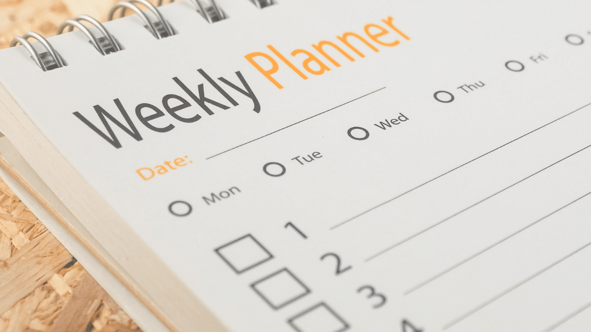 Weekly planner open on a desk, used for